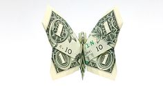 an origami butterfly made out of one hundred dollar bills is shown on a white background