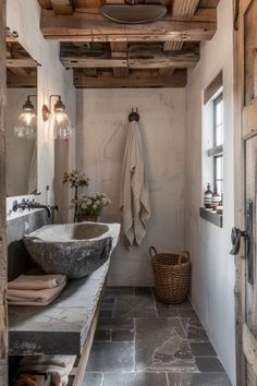 a rustic bathroom with stone sinks and wood beams on the ceiling, along with hanging lights