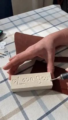 a person is making something out of wood and glues it onto the table top