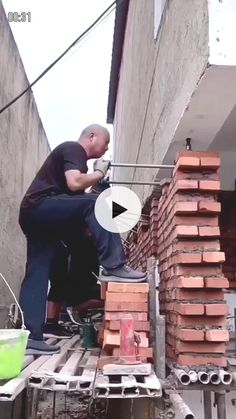 a man standing on top of a pile of bricks