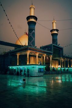 an image of a building that is lit up with green lights in the night time