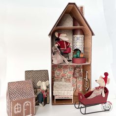 a doll house with furniture and accessories including a baby carriage, teddy bear sitting in it