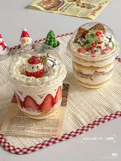 two desserts are sitting on a red and white checkered tablecloth with santa clause decorations