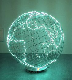 an illuminated globe sitting on top of a wooden table