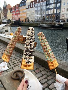 two waffles with sprinkles on them are being held by someone's hand