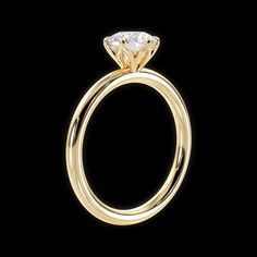 a yellow gold engagement ring with a single diamond on the top and bottom, against a black background