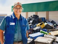 a man standing in front of a pile of junk