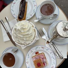 a table topped with plates and cups filled with desserts