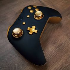 a close up of a controller on a wooden surface with gold buttons and knobs