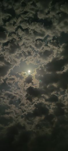 the sun is shining through some clouds in the night sky, with only one light visible