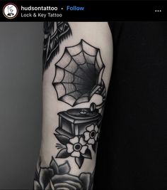 a black and white photo of a person's arm with a spider web tattoo on it