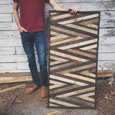 a man standing next to a wooden panel with an interesting design on the bottom and sides