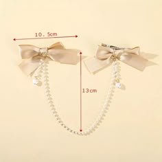 two bows with pearls are attached to the wall