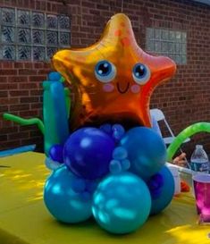 an inflatable starfish balloon sitting on top of a table with other balloons