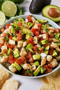 a white bowl filled with guacamole and salsa next to tortilla chips