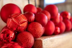 red ornaments are lined up on a shelf