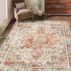 a large area rug with an ornate design on the floor in a room next to a chair