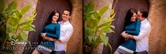 a man and woman hugging each other in front of a wooden door with green plants