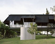 the house is made out of concrete and has an unusual roof structure that extends from the ground level to the top floor