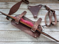 a brown leather case with a pink handle