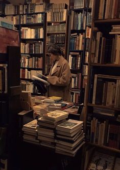 a woman standing in front of a bookshelf filled with lots of different books