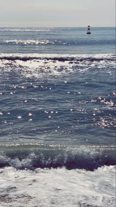 an ocean with waves and a small boat in the distance