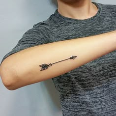 a man with a black arrow tattoo on his arm