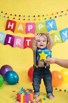 a little boy standing in front of a birthday cake