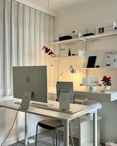 an apple computer sitting on top of a white desk