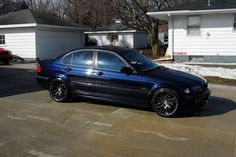 a blue car parked in front of a house