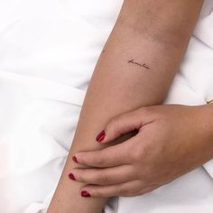 a woman's arm with a small tattoo on the left side of her arm