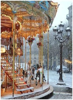 a merry go round in the snow with people on it