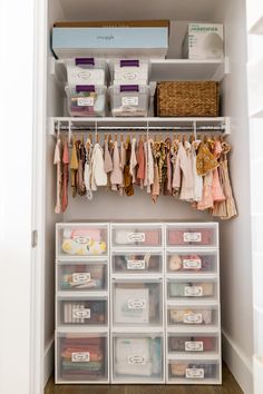 an organized closet with clear drawers and plastic bins filled with baby's clothes