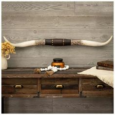 a wooden table topped with drawers and an animal's long horn on top of it