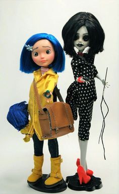 two dolls are standing next to each other with one holding a handbag and the other carrying a purse