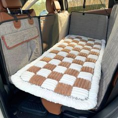 the back seat of a car with a blanket on it's side and an open trunk