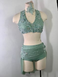 a mannequin is dressed up in green and silver clothing with sequins on it