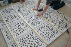 two men working on an intricately designed floor