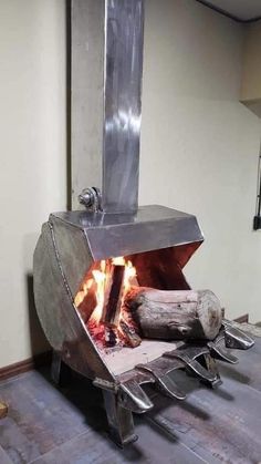 an open fire pit sitting on top of a hard wood floor next to a wall