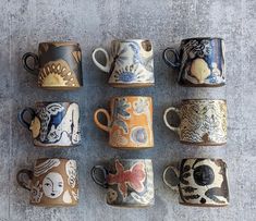 a group of coffee mugs sitting on top of a cement floor next to each other