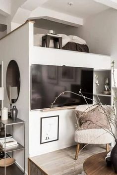 a living room filled with furniture and a flat screen tv on top of a wooden table