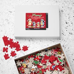 a box filled with lots of red and white puzzles next to a christmas card