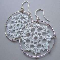 white crochet earrings with silver hoops on grey background, close up photo