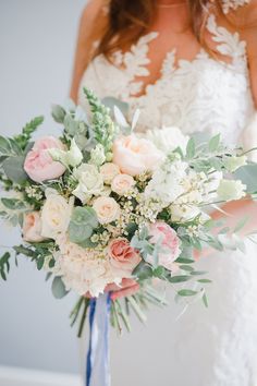 a bridal holding a bouquet of flowers and greenery