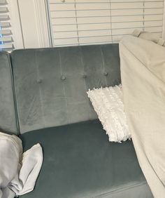 a gray couch with white sheets and pillows