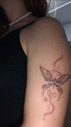 a woman's arm with a butterfly tattoo on the left side of her arm