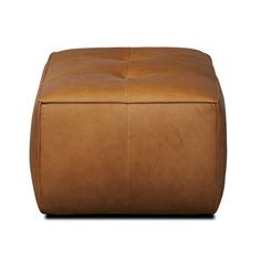 a brown leather ottoman sitting on top of a white floor