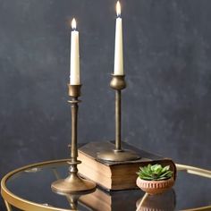 two candles sitting on top of a glass table