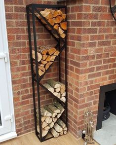 a stack of logs sitting in front of a brick wall next to a fire place