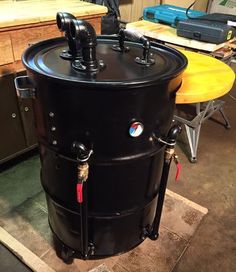 a large black barrel sitting on top of a wooden table